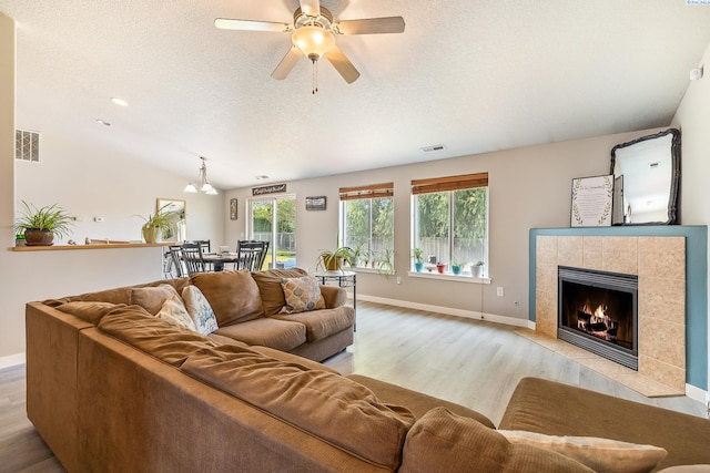 1716 W 40th Ave, Kennewick, WA 99337 - living area featuring wood finished floors, ceiling fan, a fireplace, and a textured ceiling