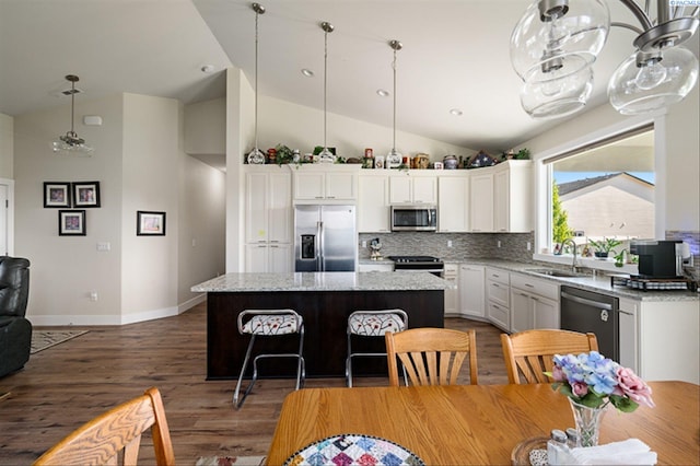 3763 S Sherman St, Kennewick, WA 99338 - kitchen with appliances with stainless steel finishes, a center island, wood finished floors, white cabinets, and tasteful backsplash