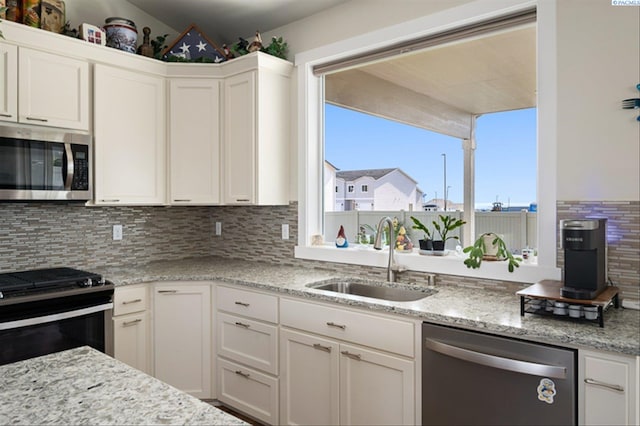 3763 S Sherman St, Kennewick, WA 99338 - kitchen with appliances with stainless steel finishes, white cabinets, decorative backsplash, and light stone counters