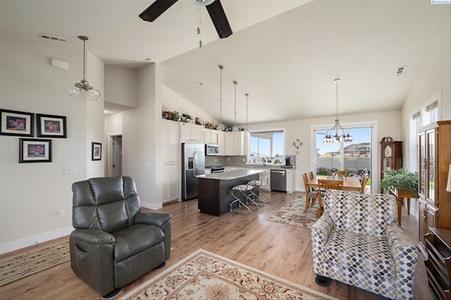3763 S Sherman St, Kennewick, WA 99338 - living room featuring light wood-style floors, healthy amount of natural light, a ceiling fan, a chandelier, and high vaulted ceiling