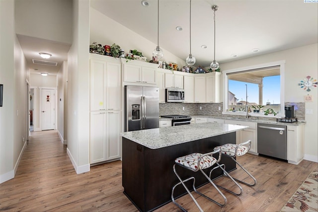 3763 S Sherman St, Kennewick, WA 99338 - kitchen featuring appliances with stainless steel finishes, decorative backsplash, wood finished floors, vaulted ceiling, and recessed lighting