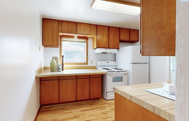 912 S Alder St, Kennewick, WA 99336 - kitchen with white appliances, under cabinet range hood, light countertops, and brown cabinetry