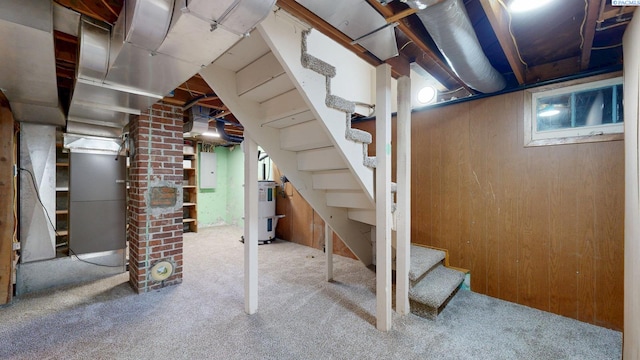 912 S Alder St, Kennewick, WA 99336 - basement featuring carpet floors, electric water heater, stairs, wood walls, and electric panel