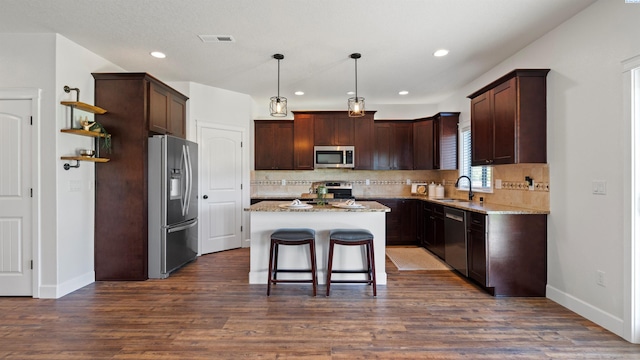 76704 E Timothy Ln, Kennewick, WA 99338 - kitchen featuring stainless steel appliances, a center island, open shelves, decorative backsplash, and a sink