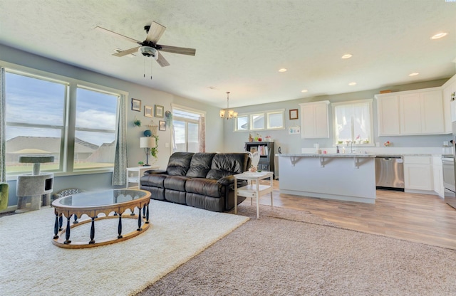 3915 Charleston Ln, Pasco, WA 99301 - living room featuring a chandelier, light wood-type flooring, recessed lighting, and a ceiling fan