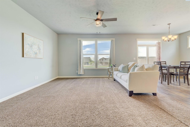 3915 Charleston Ln, Pasco, WA 99301 - living room featuring a chandelier, a ceiling fan, carpet floors, and a textured ceiling