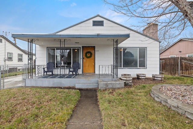 bungalow-style house with covered porch and a front lawn