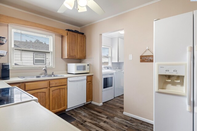 kitchen with sink, dark hardwood / wood-style flooring, ornamental molding, washing machine and dryer, and white appliances