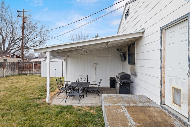 view of patio / terrace with a grill and a storage shed