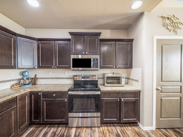 4268 Hedman Ct, Moses Lake, WA 98837 - kitchen with appliances with stainless steel finishes, dark wood finished floors, dark brown cabinetry, and tasteful backsplash