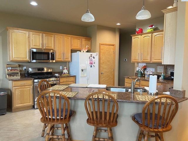 kitchen featuring a peninsula, stainless steel appliances, and a sink