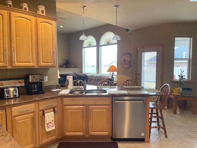 kitchen featuring a peninsula, a sink, dishwasher, a kitchen bar, and decorative light fixtures