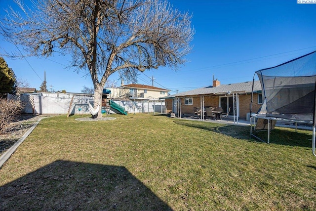 view of yard featuring a playground, a patio area, and a trampoline