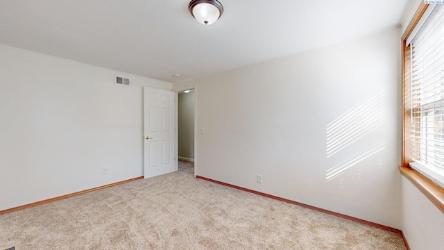 unfurnished room featuring light carpet, baseboards, and visible vents