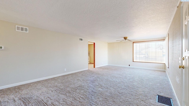 empty room with visible vents, a ceiling fan, and light colored carpet