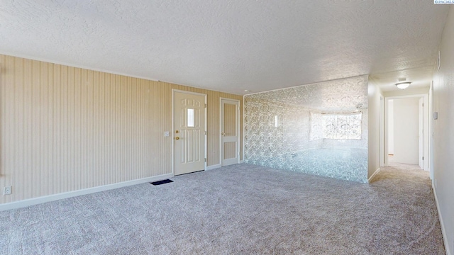 spare room featuring a textured ceiling and carpet