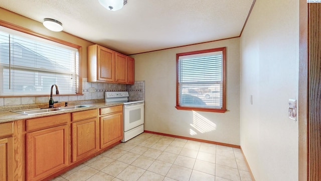 kitchen with white electric range oven, plenty of natural light, light countertops, and a sink