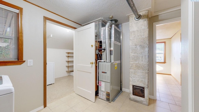 utility room with heating unit and washer / dryer