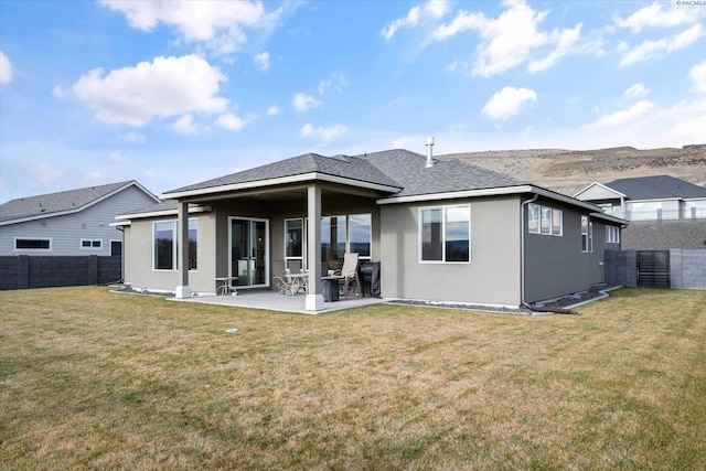 back of property with a lawn and a patio