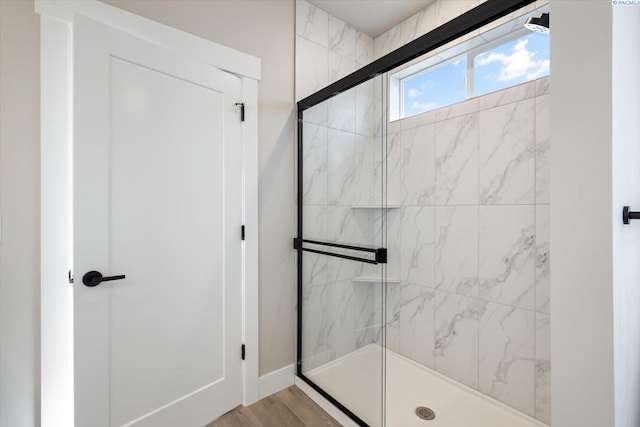 bathroom with hardwood / wood-style floors and a shower with shower door