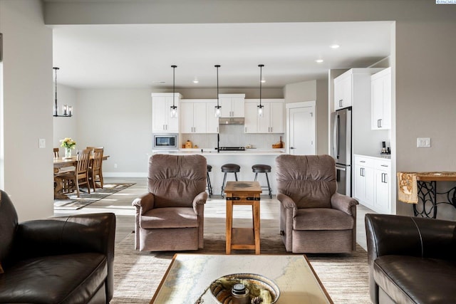 living room with an inviting chandelier and light hardwood / wood-style flooring