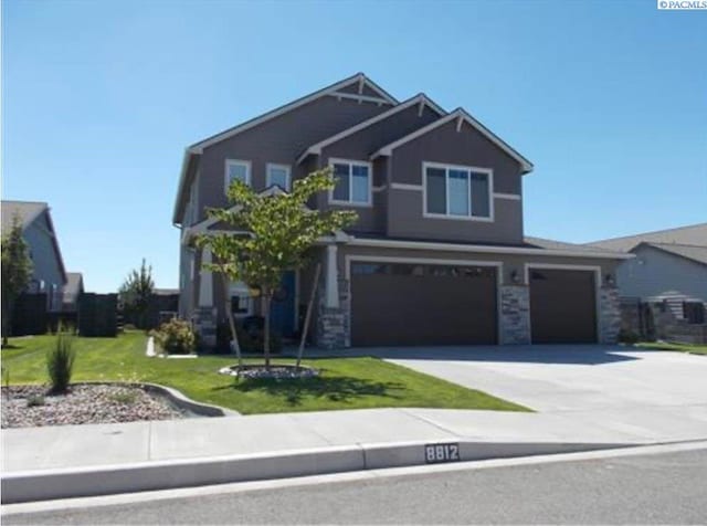 8812 Landon Ct, Pasco, WA 99301 - craftsman house with concrete driveway, a garage, a front lawn, and stone siding