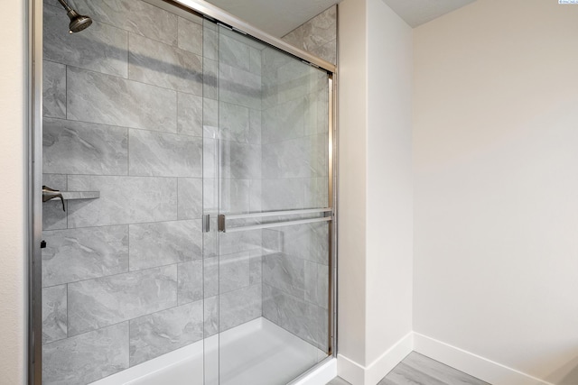 bathroom featuring hardwood / wood-style flooring and a shower with shower door