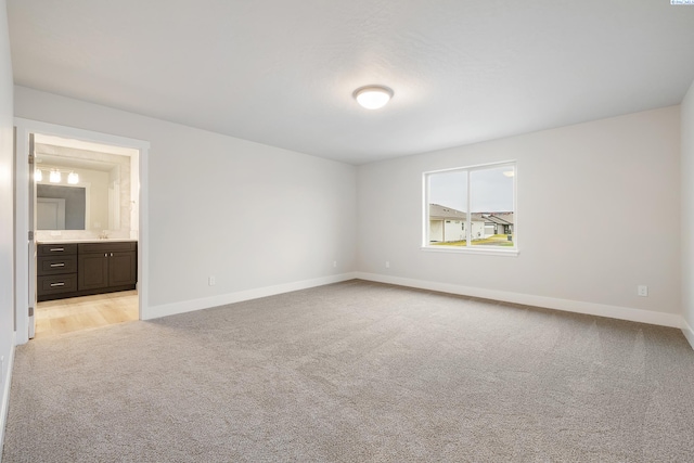 unfurnished bedroom with light carpet and sink