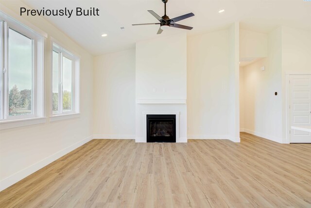 unfurnished living room featuring wood finished floors, recessed lighting, a fireplace, and baseboards