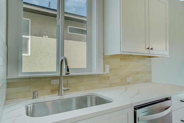 4003 Rd 96, Pasco, WA 99301 - kitchen with stainless steel dishwasher, a sink, white cabinets, backsplash, and light stone countertops