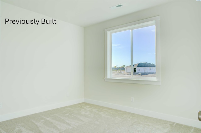 carpeted empty room featuring baseboards