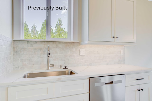 kitchen featuring dishwasher, white cabinets, backsplash, and a sink