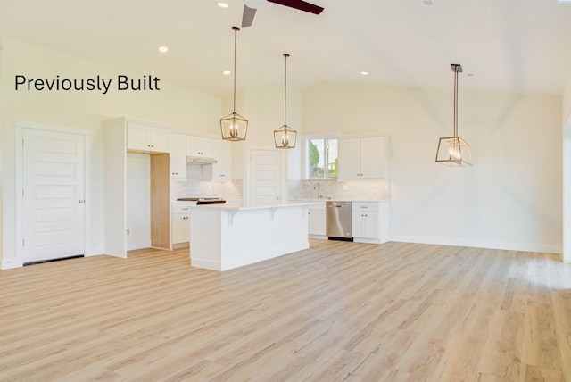 kitchen featuring a breakfast bar, a ceiling fan, stainless steel dishwasher, a center island, and white cabinets