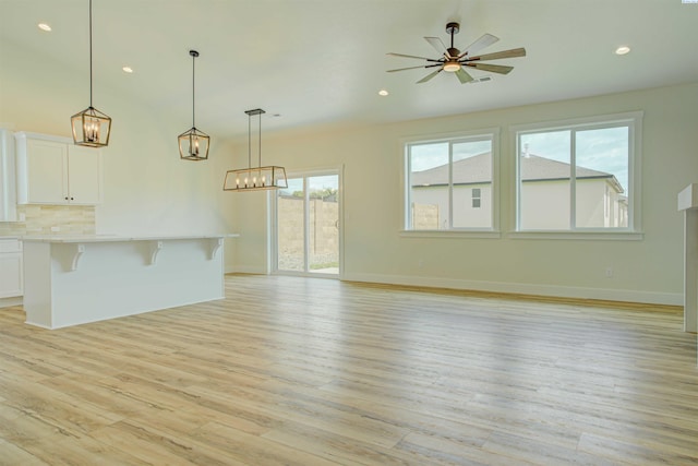 4003 Rd 96, Pasco, WA 99301 - unfurnished living room with light wood finished floors, recessed lighting, ceiling fan, baseboards, and a chandelier