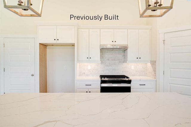 kitchen with electric stove, under cabinet range hood, backsplash, white cabinetry, and light stone countertops