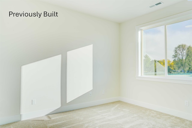 spare room with visible vents, carpet flooring, and baseboards