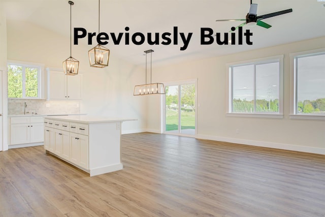 kitchen featuring decorative backsplash, plenty of natural light, light countertops, and white cabinetry