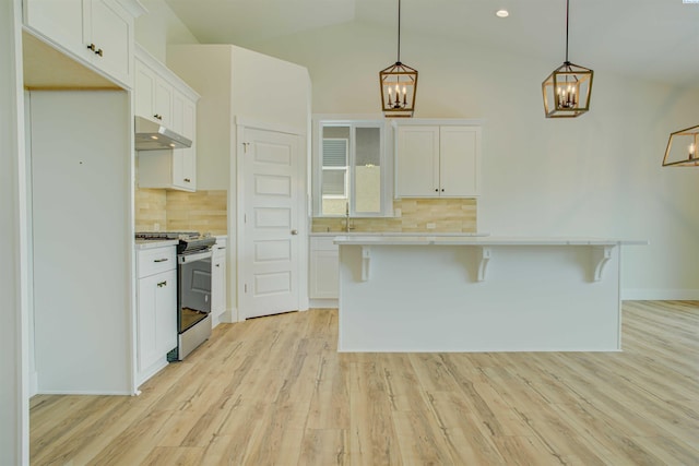 4003 Rd 96, Pasco, WA 99301 - kitchen with stainless steel range with gas stovetop, a chandelier, under cabinet range hood, light countertops, and lofted ceiling