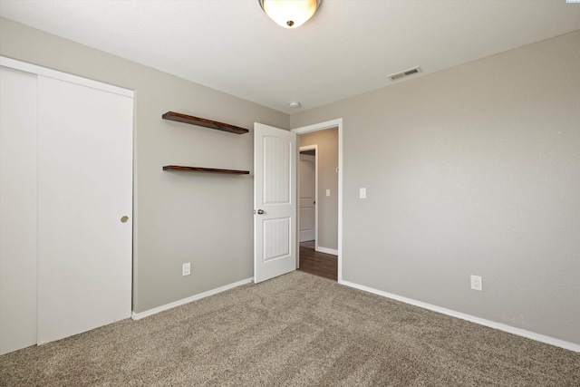 unfurnished bedroom with baseboards, carpet, visible vents, and a closet