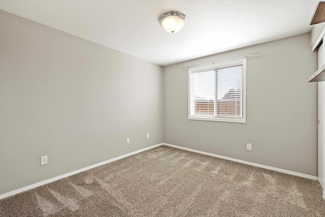 empty room with baseboards and carpet flooring