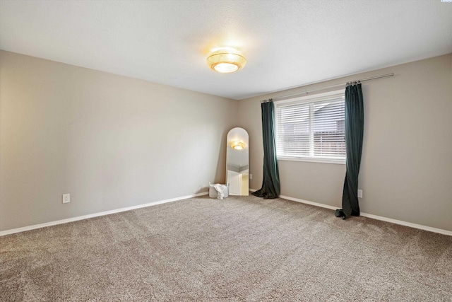 carpeted spare room with baseboards