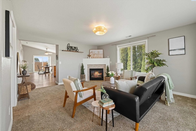 carpeted living area featuring visible vents, baseboards, a textured ceiling, and a tile fireplace