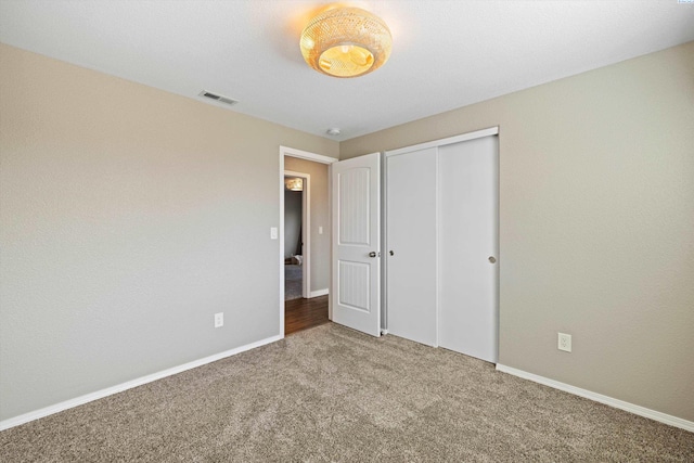 unfurnished bedroom with carpet, baseboards, and a closet