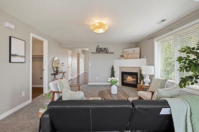 living area featuring carpet, baseboards, a fireplace, and visible vents