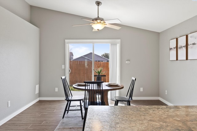 dining space featuring lofted ceiling, ceiling fan, baseboards, and wood finished floors