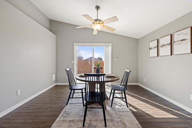 dining space with dark wood-style flooring, vaulted ceiling, and baseboards