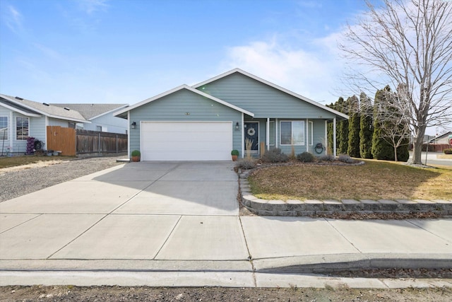 view of front of home featuring concrete driveway, fence, and an attached garage