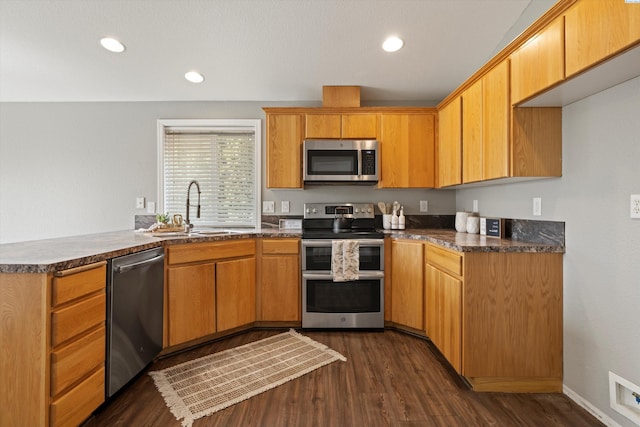 kitchen featuring stainless steel appliances, a sink, visible vents, dark wood-style floors, and dark countertops