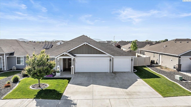 single story home with fence, a front lawn, concrete driveway, an attached garage, and a shingled roof