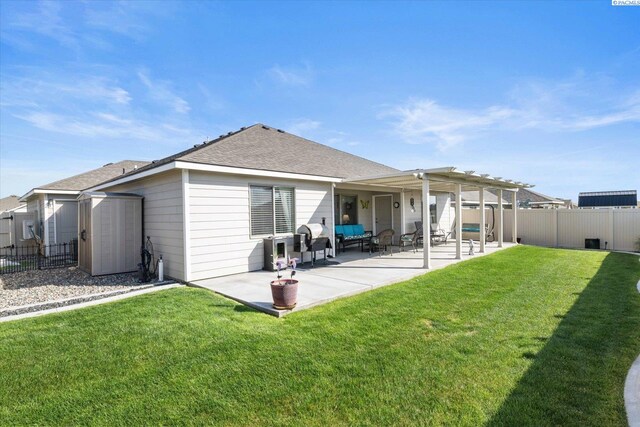 rear view of house featuring a lawn, a storage shed, a fenced backyard, a patio, and a shingled roof